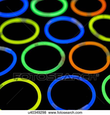 Glowstick bangles against a black background. View Large Illustration Stock Illustration - Glowstick bangles against a black background.. Fotosearch