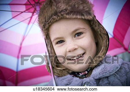 MODEL RELEASED. Young girl wearing furry hat with umbrella, portrait. View Large Photo Image Picture - MODEL RELEASED. Young girl wearing furry hat with umbrella, portrait.. Fotosearch