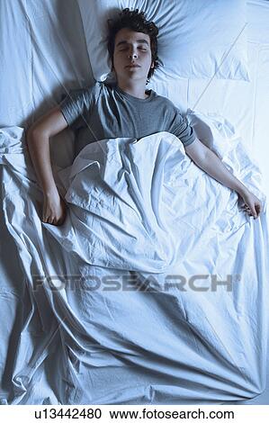 MODEL RELEASED. Young man asleep in a bed. View Large Photo Image Stock Image - MODEL RELEASED. Young man asleep in a bed.. Fotosearch