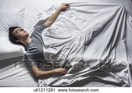 MODEL RELEASED. Young man asleep in a bed. View Large Photo Image Stock Image - MODEL RELEASED. Young man asleep in a bed.. Fotosearch