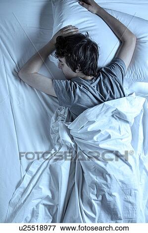 MODEL RELEASED. Young man asleep in a bed. View Large Photo Image Stock Photo - MODEL RELEASED. Young man asleep in a bed.. Fotosearch