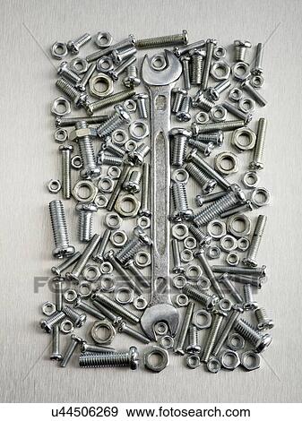 Stock Illustration - Nuts, bolts and a spanner against a grey background.. Fotosearch