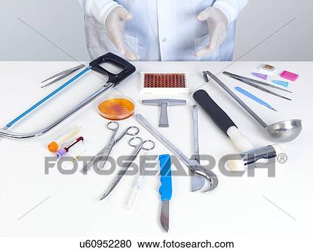 Stock Image - PROPERTY RELEASED. MODEL RELEASED. Pathologist about to perform a autopsy with his surgical equipment and tests for medical and forensic analysis.. Fotosearch