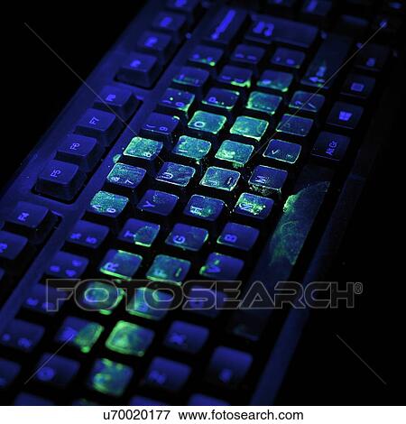 Stock Illustration - Ultraviolet light showing bacteria on a computer keyboard.. Fotosearch