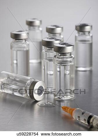 Vaccine vials and a syringe, close up. View Large Illustration Stock Illustration - Vaccine vials and a syringe, close up.. Fotosearch
