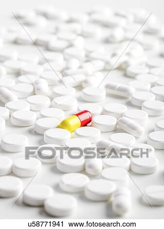 Clip Art - White tablets with a red and yellow capsule, close up.. Fotosearch