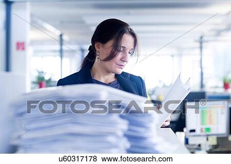 Stock Photo - Administrative staff working alone in office. Fotosearch