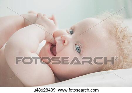 Baby girl lying down, fingers in mouth View Large Photo Image Stock Photo - Baby girl lying down, fingers in mouth. Fotosearch