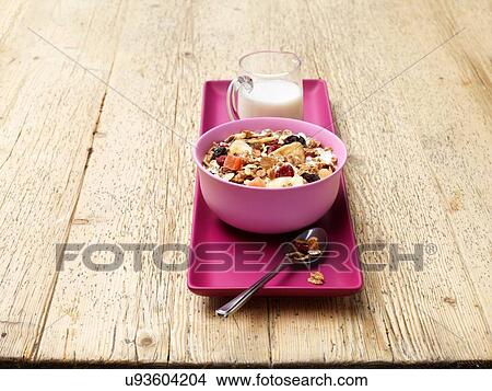 Breakfast bowl of muesli with fruit and milk on wood View Large Photo Image Picture - Breakfast bowl of muesli with fruit and milk on wood. Fotosearch