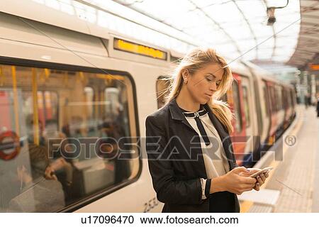 Business woman texting on platform, Underground station, London, UK View Large Photo Image Stock Image - Business woman texting on platform, Underground station, London, UK. Fotosearch