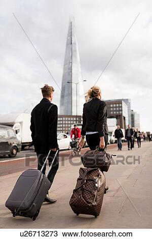 Stock Image - Businessman and businesswoman on business trip, London, UK. Fotosearch