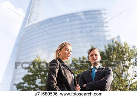 Businessman and businesswoman, buildings in background, London, UK View Large Photo Image Stock Photograph - Businessman and businesswoman, buildings in background, London, UK. Fotosearch