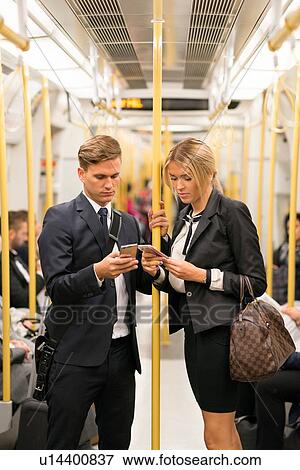 Businessman and businesswoman texting, London Underground, UK View Large Photo Image Stock Photo - Businessman and businesswoman texting, London Underground, UK. Fotosearch