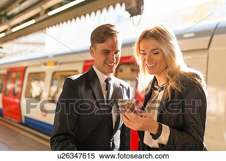 Businessman and businesswoman texting on platform, Underground station, London, UK View Large Photo Image Stock Photography - Businessman and businesswoman texting on platform, Underground station, London, UK. Fotosearch