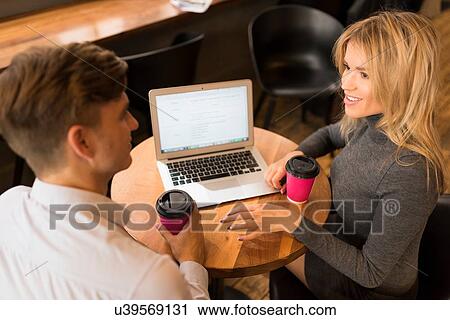 Businessman and businesswoman using laptop in cafe View Large Photo Image Stock Image - Businessman and businesswoman using laptop in cafe. Fotosearch