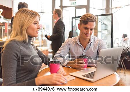 Businessman and businesswoman using laptop in cafe View Large Photo Image Stock Photograph - Businessman and businesswoman using laptop in cafe. Fotosearch