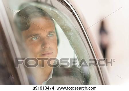 Picture - Businessman looking out of car window. Fotosearch