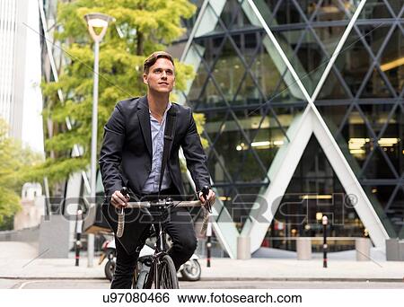 Stock Photograph - Businessman on bike, 30 St Mary Axe in background, London, UK. Fotosearch