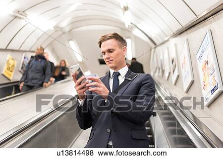 Businessman texting on escalator, London Underground, UK View Large Photo Image Stock Photo - Businessman texting on escalator, London Underground, UK. Fotosearch