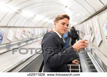 Businessman texting on escalator, London Underground, UK View Large Photo Image Stock Photo - Businessman texting on escalator, London Underground, UK. Fotosearch