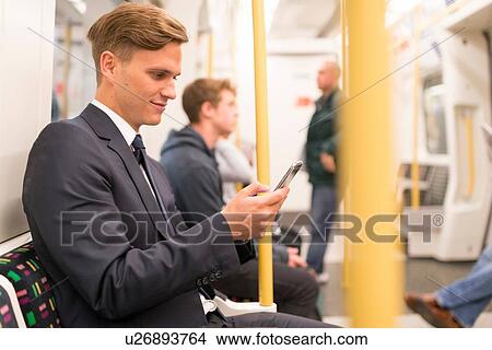 Businessman texting on tube, London Underground, UK View Large Photo Image Picture - Businessman texting on tube, London Underground, UK. Fotosearch