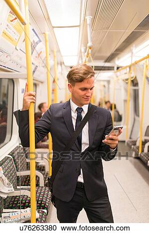 Businessman texting on tube, London Underground, UK View Large Photo Image Stock Image - Businessman texting on tube, London Underground, UK. Fotosearch