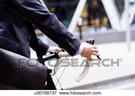 Businessman walking with bike View Large Photo Image Stock Photo - Businessman walking with bike. Fotosearch