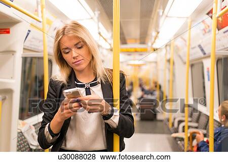 Businesswoman texting on tube, London Underground, UK View Large Photo Image Stock Photo - Businesswoman texting on tube, London Underground, UK. Fotosearch