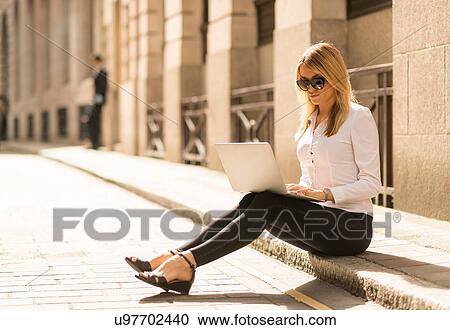 Businesswoman using laptop on kerb, London, UK View Large Photo Image Stock Image - Businesswoman using laptop on kerb, London, UK. Fotosearch