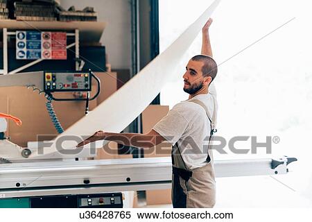 Stock Photography - Carpenter with sheet of plywood. Fotosearch