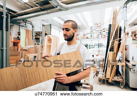 Stock Image - Carpenter working on wood. Fotosearch