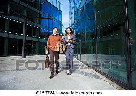 Stock Image - Casual businessman and woman on way to work. Fotosearch