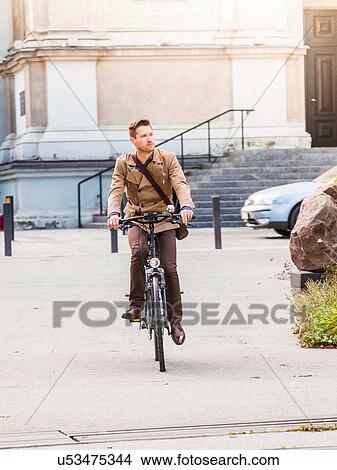 Picture - Casual businessman cycling in Warsaw, Poland. Fotosearch