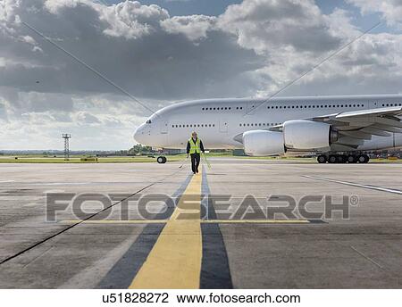 Chief engineer walking from runway as A380 aircraft departs from airport View Large Photo Image Stock Image - Chief engineer walking from runway as A380 aircraft departs from airport. Fotosearch