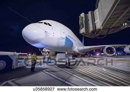 Stock Photo - Chief engineer with A380 aircraft on runway at night. Fotosearch