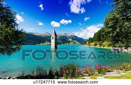 Stock Photography - Church spire in turquoise lake, Trentino Alto Adige, Italy. Fotosearch