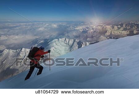Stock Photo - Climber moving up through deep snow, Swiss Alps, Canton Wallis, Switzerland. Fotosearch