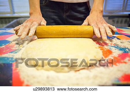 Close up of womans hands rolling dough on kitchen table View Large Photo Image Stock Image - Close up of womans hands rolling dough on kitchen table. Fotosearch