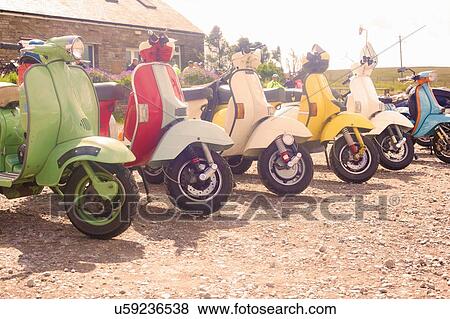 Colourful scooters parked in a row View Large Photo Image Stock Photo - Colourful scooters parked in a row. Fotosearch