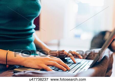 Cropped mid section of mid adult woman typing on laptop computer View Large Photo Image Stock Photo - Cropped mid section of mid adult woman typing on laptop computer. Fotosearch