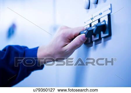 Cropped view of young mans hand adjusting dial on switchgear View Large Photo Image Stock Photo - Cropped view of young mans hand adjusting dial on switchgear. Fotosearch