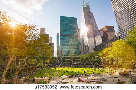 Stock Image - Crowds in Central Park and city skyline, New York, USA. Fotosearch