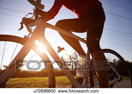 Cyclist riding during sunset View Large Photo Image Stock Image - Cyclist riding during sunset. Fotosearch