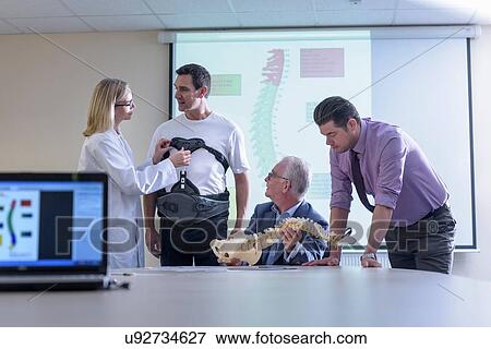 Stock Photo - Designers in meeting discuss orthopaedic back support. Fotosearch