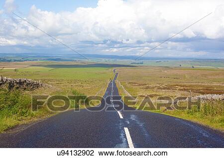Stock Image - Diminishing perspective of rural road, Cumbria, UK. Fotosearch