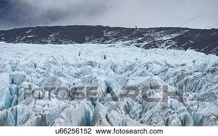 Stock Image - Distant hiker on mountain at Svinafellsjokull glacier, Iceland. Fotosearch