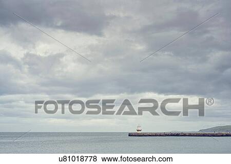 Distant view of harbour wall, Cumbria, UK View Large Photo Image Stock Photo - Distant view of harbour wall, Cumbria, UK. Fotosearch