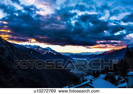 Distant view over snow covered rooftops at dusk, Valtellina, Italy View Large Photo Image Stock Photo - Distant view over snow covered rooftops at dusk, Valtellina, Italy. Fotosearch