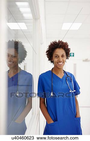 Doctor leaning against glass window in hospital View Large Photo Image Stock Image - Doctor leaning against glass window in hospital. Fotosearch
