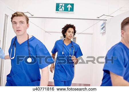 Stock Photograph - Doctors running into emergency room in hospital. Fotosearch